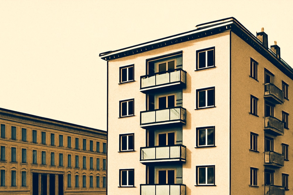 Zweifarbige Linienillustration: typisches Wohnhaus vor einem Regierungsgebäude