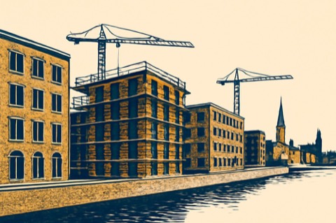 Krane über einem mittelgeschossigen Wohnungsbau an einem deutschen Stadtkai